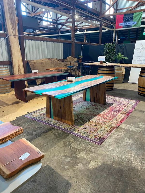 Turquoise river table on slab legs over a Persian rug