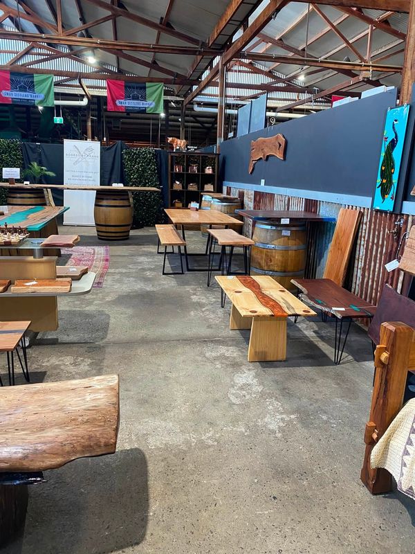 Wide view of stall: tables, benches, barrels, boards on wall