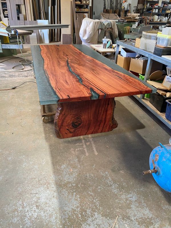 End view of the jarrah table with grey resin edges, in the workshop