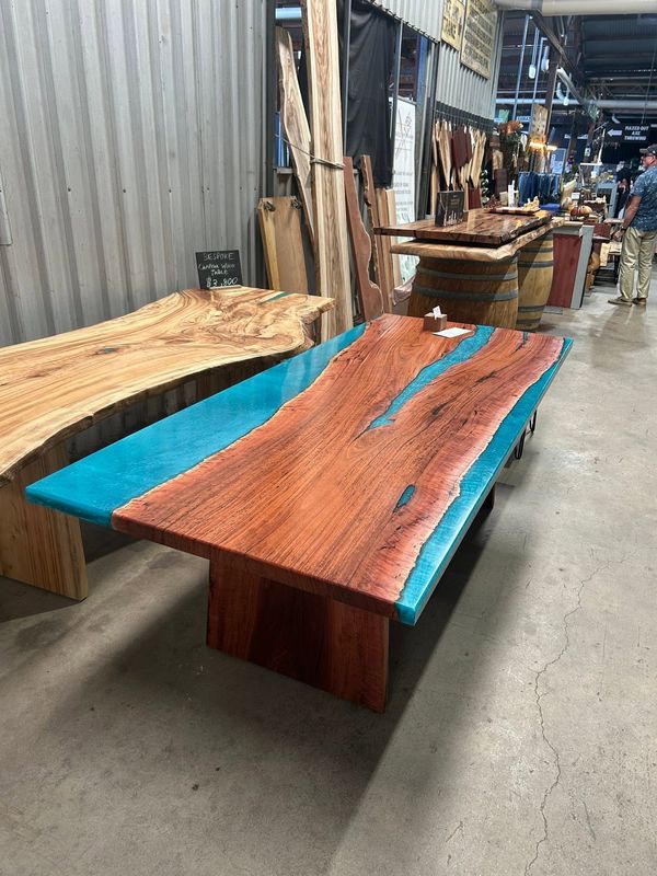 Turquoise river table beside a blonde live-edge slab