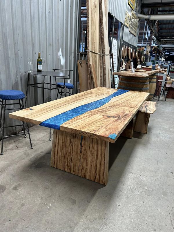 Pale timber table with blue resin river, slab legs