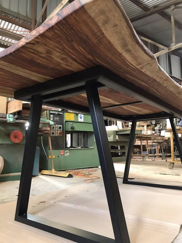 Underside: live-edge top on black trapezoid legs