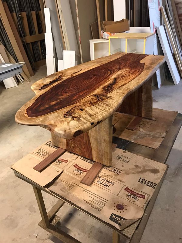 Sheoak live-edge slab on its base in the workshop