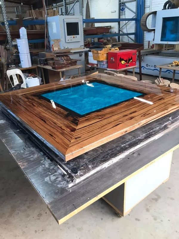 Table with a cured resin river inside a timber frame