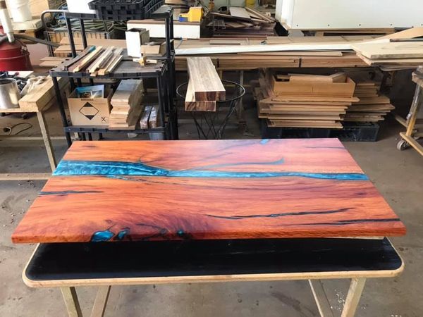 Orange marri table with a blue resin river, wide view